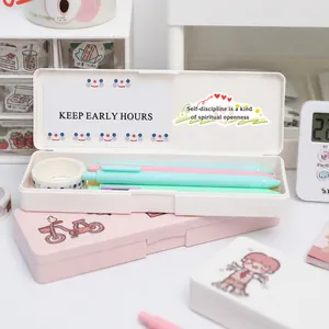 Minimalist white and pink plastic pencil boxes with macaron pens on a desk