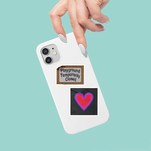 Close-up of white phone case featuring retro sticker text and a red glowing heart pattern