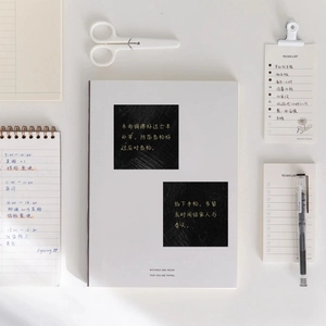 Inspirational Chinese quote stickers on minimalist white notebook with stationery items