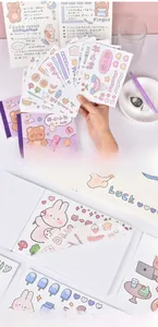 Close-up of waterproof washi paper bear stickers being applied to a journal notebook