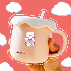 Pink ceramic bear mug with white cream lid and blue straw on red cloud background