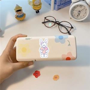 Matte beige Schreibwarenbox mit süßem Hasen und Blumenmuster auf einem Schreibtisch