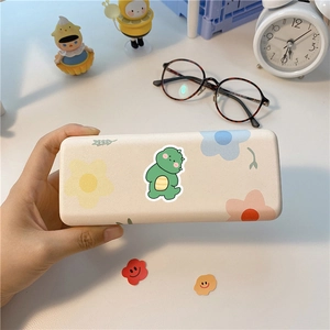 Cute beige storage box with cartoon dinosaur and floral patterns on a desk