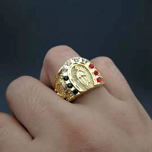 Bague Vierge Marie en acier doré avec strass colorés portée sur le doigt