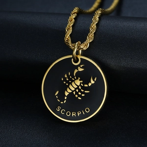 Macro detail of gold Scorpio pendant with black enamel and a twisted rope chain