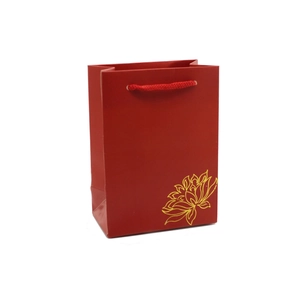 Red paper jewelry gift bag with golden lotus pattern and red woven handles on white background