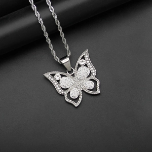 Gros plan du pendentif papillon évidé en argent avec cristaux blancs et chaîne torsadée