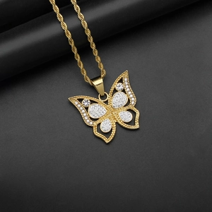 Collier hip hop avec pendentif papillon doré évidé et pierres sur fond noir élégant