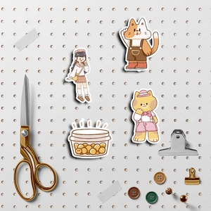 Cute cartoon cat and girl stickers displayed on a pegboard with DIY stationery tools