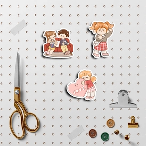 Macro shot of cute cartoon character stickers on white pegboard with stationary tools