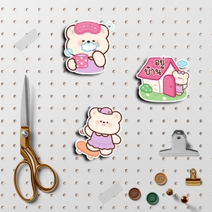 Detail of cute pink and purple bear stickers on a gray pegboard with DIY craft accessories