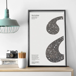 Modern black framed Times New Roman typography art poster displayed on a wooden desk