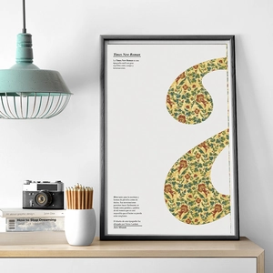 Framed vintage floral letter S poster with black thin frame in a modern office setup