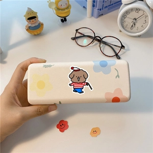 Dettaglio di un portaocchiali color crema con stampa di cane e fiori colorati