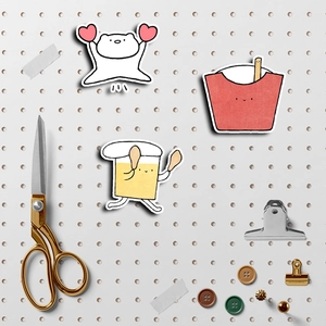 Cute cartoon scrapbook stickers with bear and snacks on a grey metal pegboard organizer
