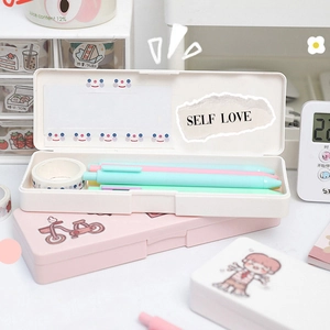 Pastel pink and white stationery box with pens and decorative tape on a desk