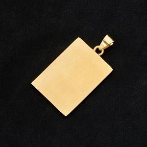 Detail of a gold rectangular pendant with a brushed metal finish and polished bail