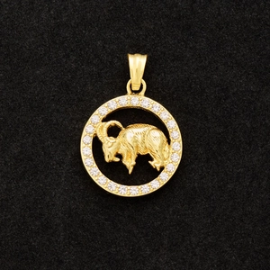 Macro shot of gold-plated Aries pendant featuring 3D goat relief and CZ crystals
