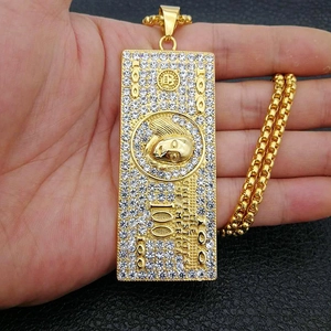 Detailed macro of gold-plated hip hop dollar bill pendant with white rhinestones