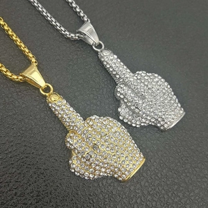 Dettaglio dei ciondoli hip-hop dito medio in oro e argento con cristalli lucidi