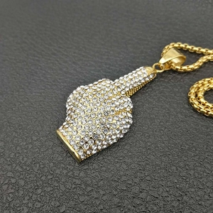 Dettaglio del ciondolo hip hop placcato oro con strass scintillanti e catena box