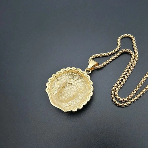 Macro shot of gold Indian Chief pendant with wavy edges and durable steel box chain