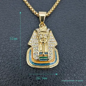 Macro detail of gold plated Egyptian Pharaoh pendant with white crystals and enamel inlay