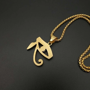 Macro shot of gold Eye of Horus pendant with diamond-set details and box chain
