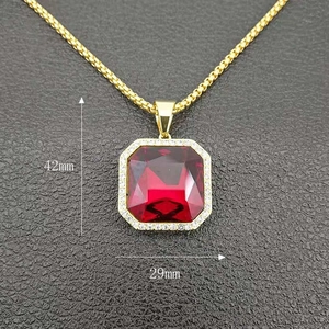 Macro detail of a 42mm gold-plated hip hop pendant featuring a large red zircon stone