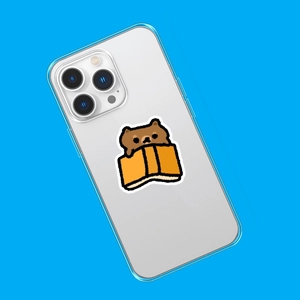 Detail of transparent silicone phone case featuring cute brown bear and orange book design