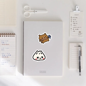Detailed view of cute bear and snowman decorative stickers on a white notebook cover