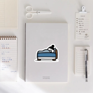 Gros plan d'un autocollant de personnage mignon sur un carnet blanc et papeterie