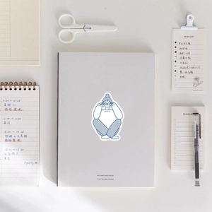 Détail de l'autocollant d'illustration de fille bleue sur un carnet blanc avec accessoires
