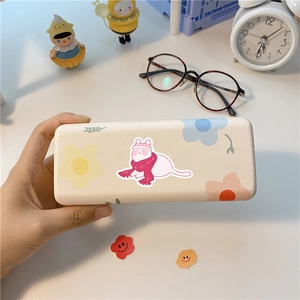 Close-up of a cream hardshell eyewear case featuring a cute cartoon cat and floral patterns