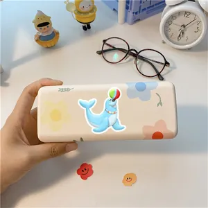 Detail shot of a beige eyeglass case with seal cartoon patterns on a desktop