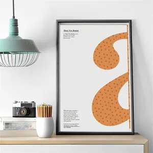 Modern black framed art with orange dots and text on wooden desk with vintage camera