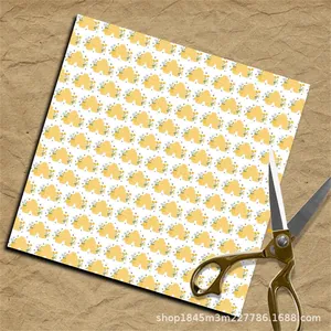 Detail of bee and floral pattern paper for scrapbooking next to metal scissors