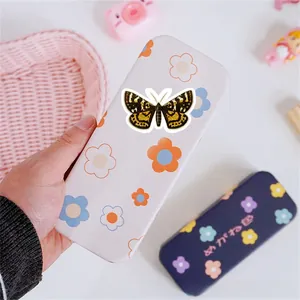 Detail showing vintage floral and butterfly patterns on a textured glasses storage case