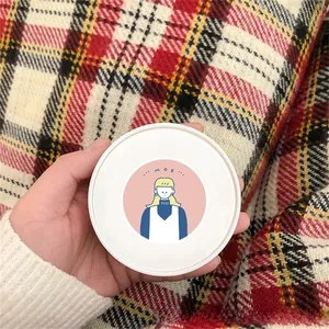 Gros plan d'un pot cosmétique blanc avec un autocollant de fille de dessin animé mignon