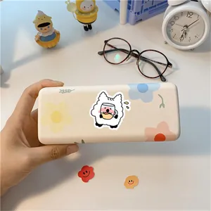 Handheld view of a matte cream glasses case with floral alpaca patterns and cute hand-drawn art