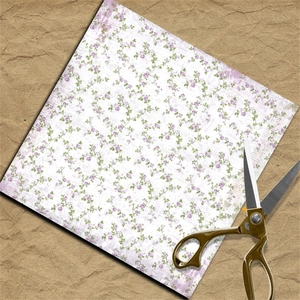 Close-up of floral scrapbook paper with vintage purple flowers and gold scissors