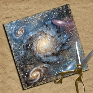 Detail of vintage blue galaxy scrapbook paper with mandala patterns and gold scissors