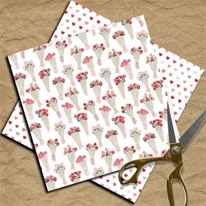 Nahaufnahme von Vintage-Scrapbook-Papier mit Blumen- und Herzmustern und goldener Schere