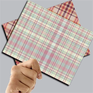 Close-up of pink and brown plaid decorative craft papers held by hand for scrapbooking
