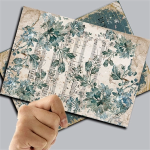 Close-up of vintage scrapbook paper featuring blue floral patterns and music scores
