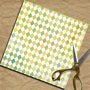 Close-up of harlequin plaid scrapbook paper with vintage gold scissors on kraft paper