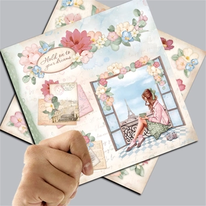 Detail of vintage scrapbooking paper featuring Eiffel Tower illustrations and floral motifs