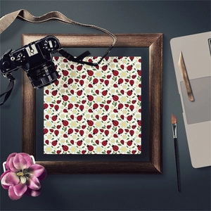 Detail of vintage ladybug pattern paper in a dark wood frame with art supplies