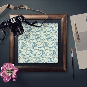 Flat lay of vintage scrapbooking paper with blue floral patterns and art supplies