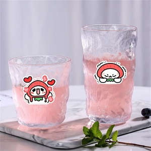 Cute cartoon strawberry cat stickers on textured glass cups with refreshing drinks